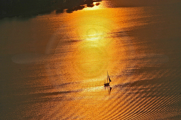 Sunset Over Lone Sailboat